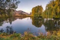 Garden pond surrounded by willow trees at sunset in autumn Royalty Free Stock Photo