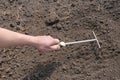 Garden rake in a hand against the background of soil, dirt ground. The concept of spring gardening Royalty Free Stock Photo