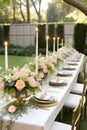 Garden reception decor with flower pots, flowers, golden spoons, plates, and candlelight placed on the table.