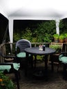 Garden seating area covered by a white gazebo at night lit by bright white light with pot plants and decking Royalty Free Stock Photo