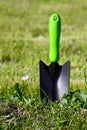 Garden shovel with green handle is stuck in the ground Royalty Free Stock Photo