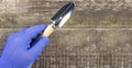 Garden shovel in the hand of a man in a working glove on a rustic background, copy space Royalty Free Stock Photo