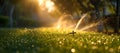 Tranquil garden at sunrise with sprinkler watering fresh grass. nature background, relaxation scene, early morning dew Royalty Free Stock Photo