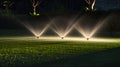 Garden sprinklers at night emitting a fine spray over lush green grass, highlighting the peacefulness of the garden