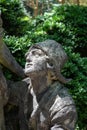 Garden statue of a boy looking up, sunlit face
