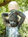 garden statue. child figure with lamp globe on his head. dirty with cobwebs.