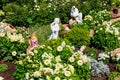 Garden statues of angels and animals on flowerbed