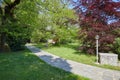 Garden with stone tiled path and street lamp in a sunny day, Italy