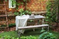 Garden in summer with patio, wooden garden furniture and barbecue. Dining table in backyard. Cozy space in patio or balcony. Outsi