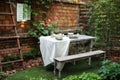 Garden in summer with patio, wooden garden furniture and barbecue. Dining table in backyard at home. Cozy space in patio or balcon