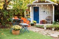 Garden table and chairs with apples and pumpkins on autumn yard. Terrace with retro light bulbs garlands. Beautiful porch home wit Royalty Free Stock Photo