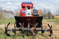 Garden tiller to work, tractor cultivating field at spring, loosens soil by petrol cultivator Royalty Free Stock Photo