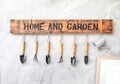 Garden tool hanging on concrete wall with wooden label