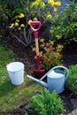 Garden tool shovel spade old zinc watering can bucket bag in garden with flowers and grass.