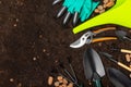 Garden tools on the background of the texture of fertile soil. Royalty Free Stock Photo