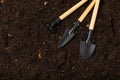 Garden tools on the background of the texture of fertile soil. Royalty Free Stock Photo