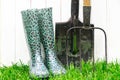 Garden tools and gardening shoes stand in the garden before work begins. Tools for gardening Royalty Free Stock Photo