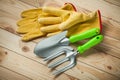 Garden tools. hand spade and fork with yellow leather gloves on wooden background Royalty Free Stock Photo