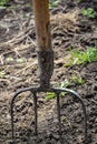 Garden tools. Pitchfork stuck in the ground. Selective focus. Preparation for digging up the garden. Close-up