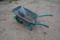 Dirty metal garden wheelbarrow on bare ground Royalty Free Stock Photo