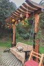 Garden wooden swing with a canopy decorated with flowers Royalty Free Stock Photo