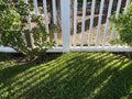 garden wooden white wood picket fence grass yard sunlight shadow backyard Royalty Free Stock Photo