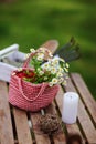 Garden work still life in summer. Chamomile flowers in red handmade bag