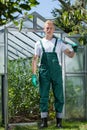 Garden worker standing in front of glasshouse