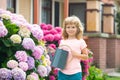 Garden works. Spring gardening. Kid with watering can in garden. Plant and care flowers. Royalty Free Stock Photo