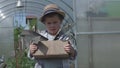 In garden young boy in hat holding gardening tools little helper close-up. Little helper world of agriculture joys