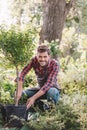 Gardener in apron planting tree while working in garden Royalty Free Stock Photo