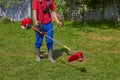 A gardener with a brush cutter in the yard,work on mowing the grass with a new brush cutter Royalty Free Stock Photo