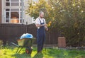 Gardener cleans the rake from the leaves. Gardening and yard cleaning Royalty Free Stock Photo