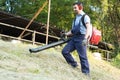 Gardener clearing up the leaves using a leaf blower Royalty Free Stock Photo