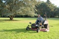 Gardener cutting grass garden on lawn mower Royalty Free Stock Photo