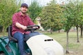 Gardener cutting the grass of a garden seated on a lawn mower Royalty Free Stock Photo