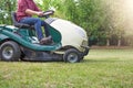 Gardener cutting the grass of a garden seated on a lawn mower Royalty Free Stock Photo