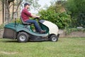 Gardener cutting the grass of a gardenon a lawn mower Royalty Free Stock Photo