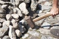 a gardener in dirty work clothes and boots holds a two-bladed iron hammer Royalty Free Stock Photo