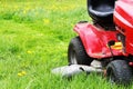 Gardener driving a riding lawn mower in a garden . Cutting grass Royalty Free Stock Photo