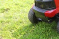 Gardener driving a riding lawn mower in a garden . Cutting grass Royalty Free Stock Photo