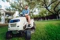 Professional landscaper using tractor at mowing lawn