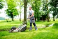 Gardener equipped with lawnmower on the job