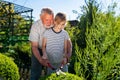 Gardener grandpa teaches granddaughter to cut the bushes gardening shears