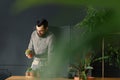 Gardener in grey shirt taking care of succulents in the orangery