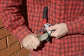 Gardener Hands Sharpen Pruning Shears. Gardener Cleaning and Sharpening Garden Tools. Royalty Free Stock Photo