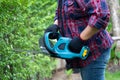 Gardener holding electric hedge trimmer to cut the treetop in garden. Hobby planting home garden Royalty Free Stock Photo