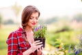 Gardener holding a seedling in flower pot, smelling it Royalty Free Stock Photo