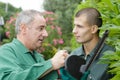 gardener instructing apprentice to cut hedge Royalty Free Stock Photo