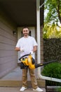 Gardener man clearing up the leaves using a leaf blower tool Royalty Free Stock Photo